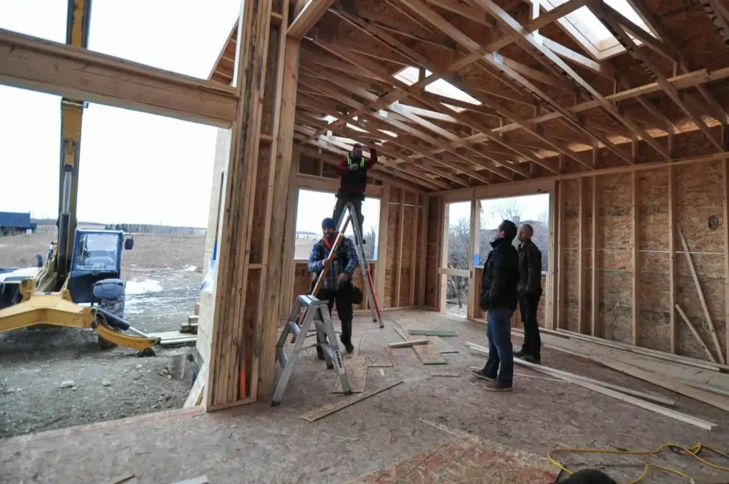 A team of builders inspects the interior of a new house frame in Calgary.