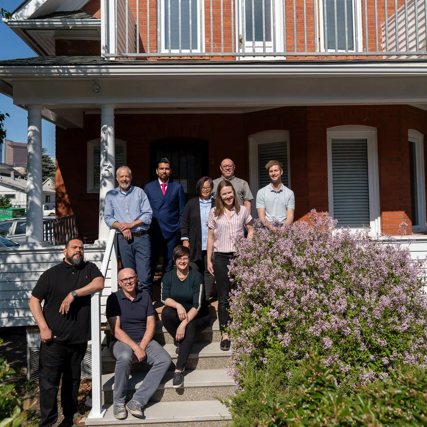 A team of residential designers in Calgary stand outside on the balcony of their office.